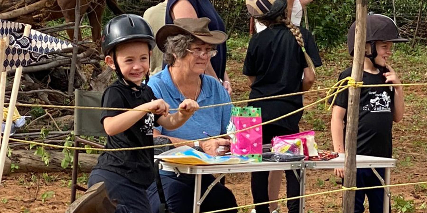 Children participating in riding gymkhana games with instructor at Wild Bhiza family-friendly equestrian activities in Chisuma Village Zimbabwe near Victoria Falls