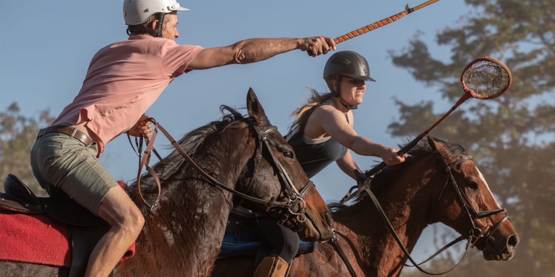 Riders playing mounted games polocrosse-style activities on horseback at Wild Bhiza in Chisuma Village Zimbabwe near Victoria Falls showing dynamic equestrian sports