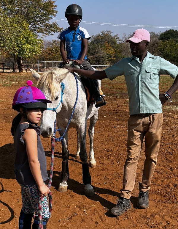 Local Youth Learning Horse Riding Wild Bhiza Zimbabwe Community Education Program Local Zimbabwean youth learning horse riding skills at Wild Bhiza Stables near Victoria Falls, community education and empowerment program creating employment opportunities