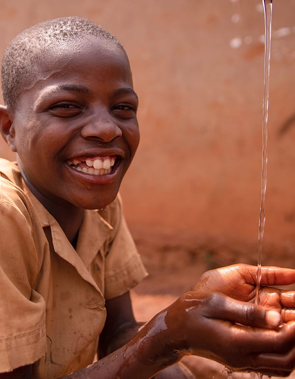 Local-Youth-Portrait-Community-Connection-Wild-Bhiza-Zimbabwe-Village Smiling local Zimbabwean youth portrait showing genuine joy and community connection in Chisuma Village during Wild Bhiza cultural exchange near Victoria Falls
