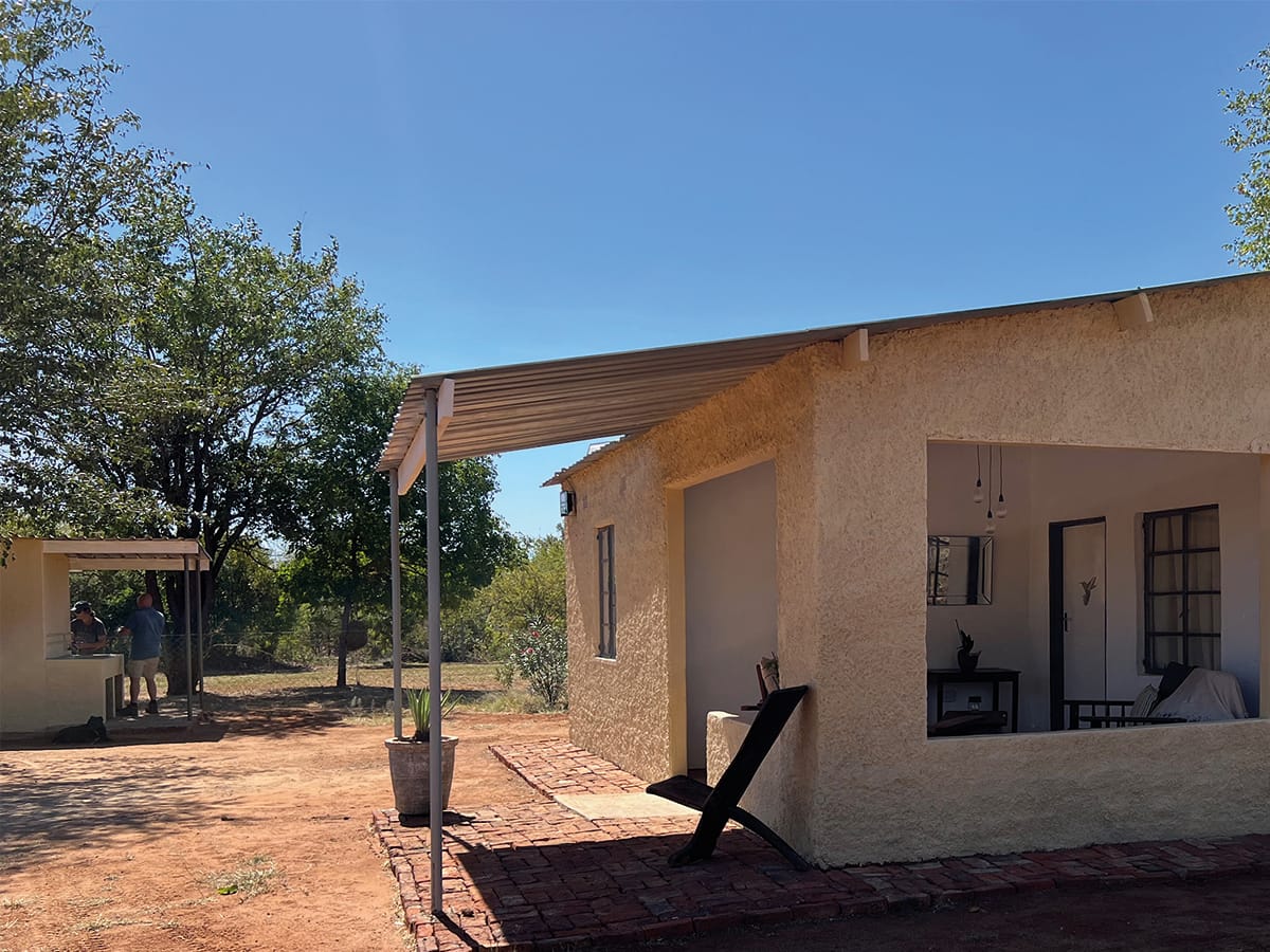 Modern accommodation building with shaded patio at Wild Bhiza Chisuma Village Zimbabwe