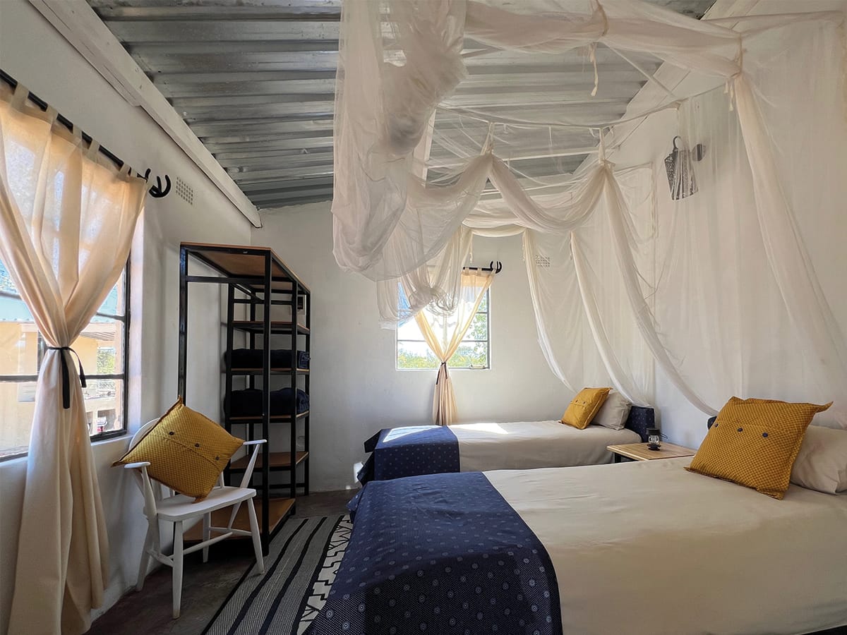 Comfortable bedroom with mosquito netting at Wild Bhiza African homestead accommodation Victoria Falls Zimbabwe